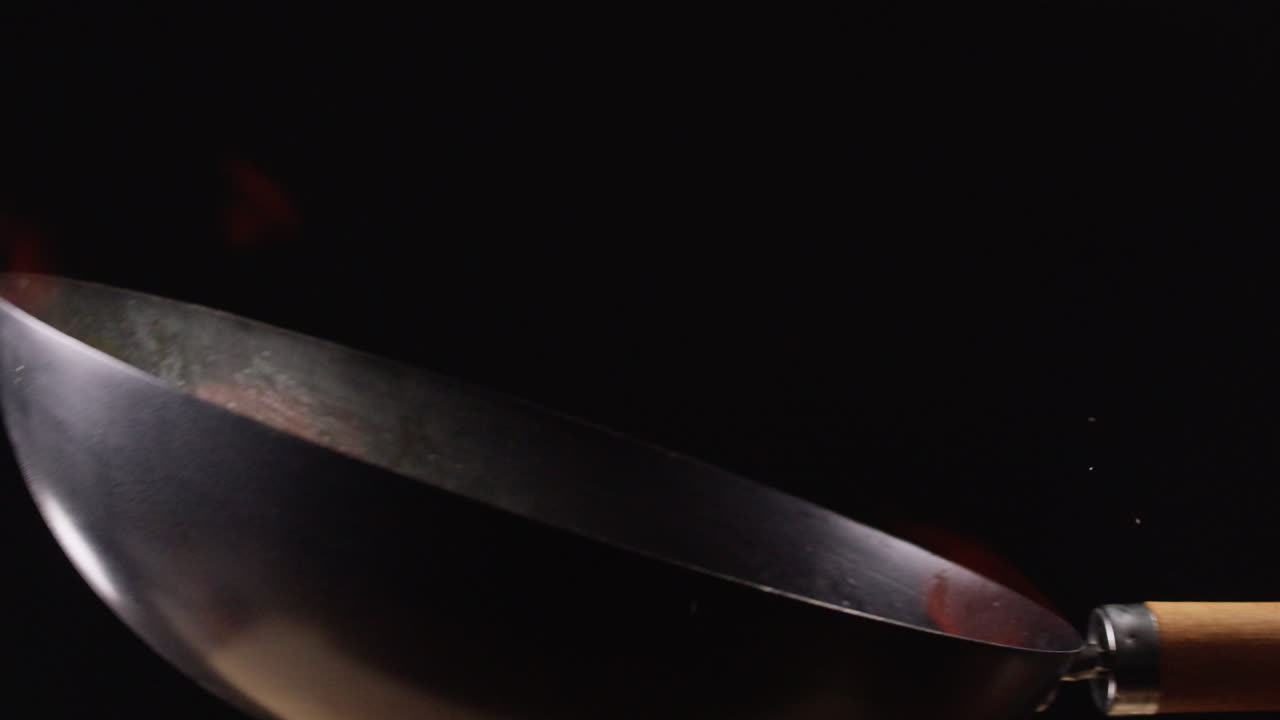 Cottura di stir-fry in un wok con fiamme