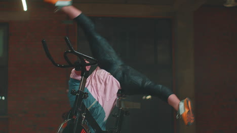 athletic woman makes twine training routine on spinning stationary bike in gym, stretching exercises