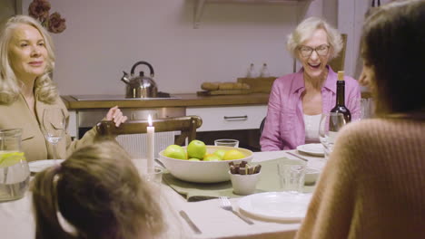 little girl bringing pie to the table during a dinner with her happy family 1