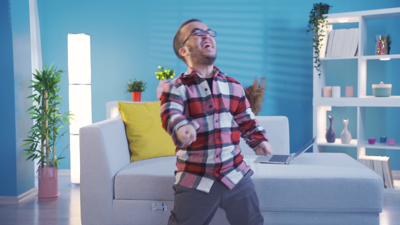 Disabled dwarf young man very happy and rejoices using laptop. Success concept.