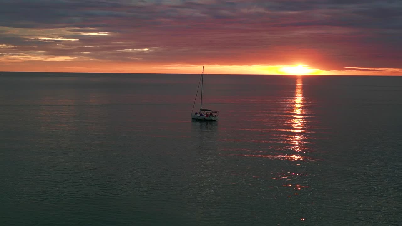 gran cielo sobre silueta velero rayos de sol reflejo en el agua