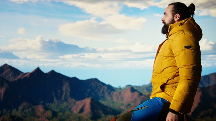 Un escursionista determinato guarda l'epica catena montuosa e le attrazioni turistiche