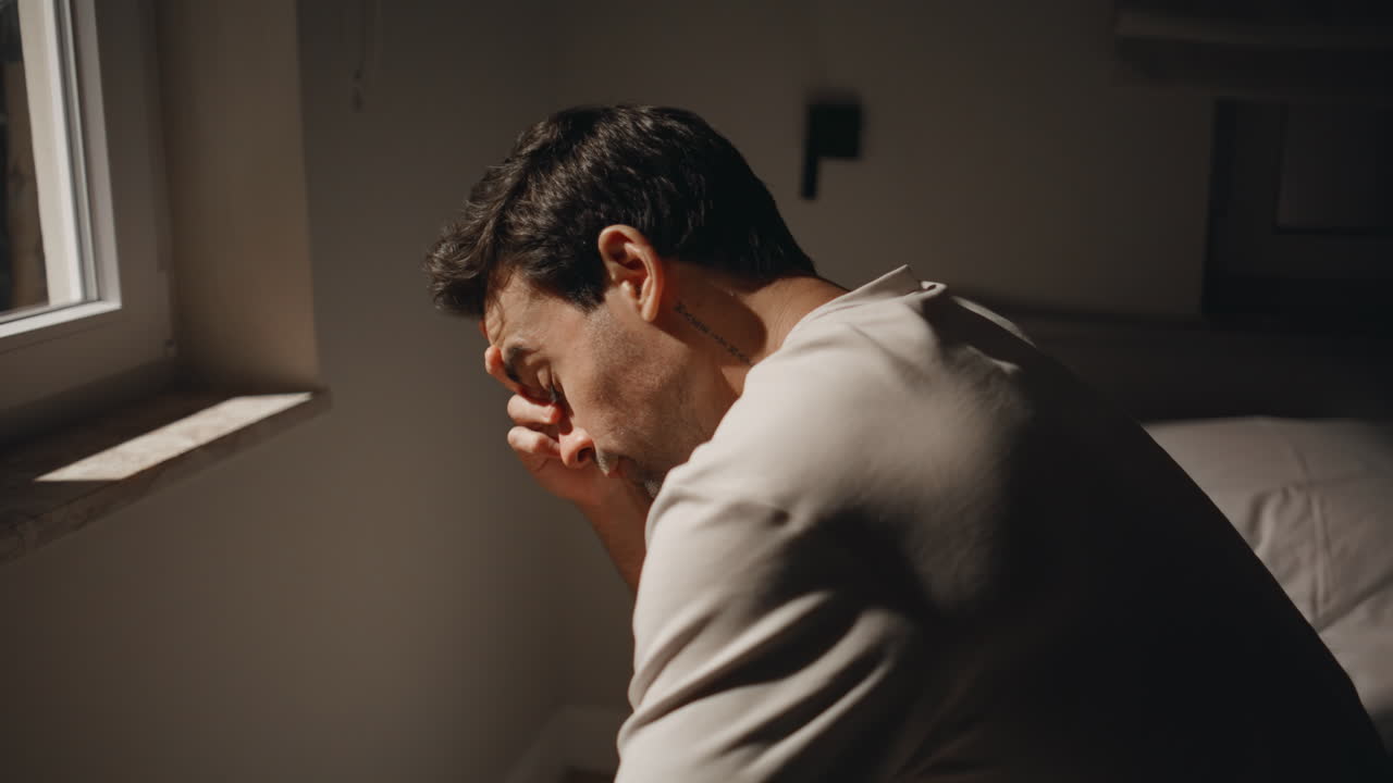 Stressed man sitting night bedroom by window closeup. Guy feeling depression