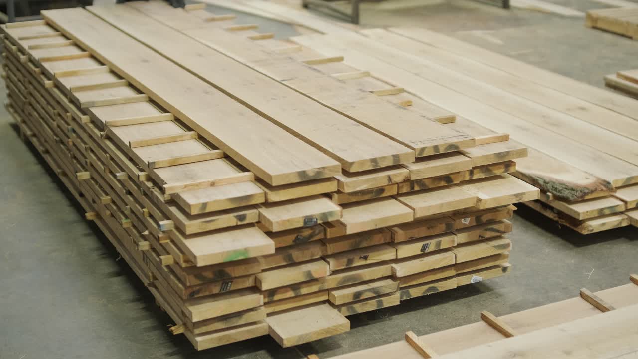 Operaio che impila assi di legno in un laboratorio di falegnameria
