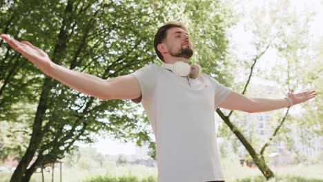 Man-jogger-meditating,-breathes-deeply-with-mudra-gesture,-praying-eyes-closed-keep-calm-down,-relax