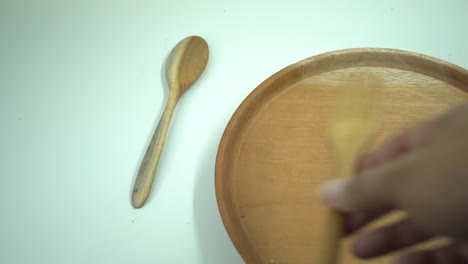 galleta de navidad sobre el plato de madera, tenedor y cuchara con fondo blanco.