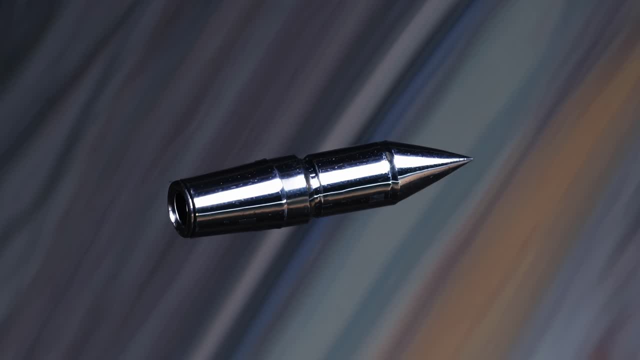 Shiny Metallic Dart Tip Spinning on Abstract Background