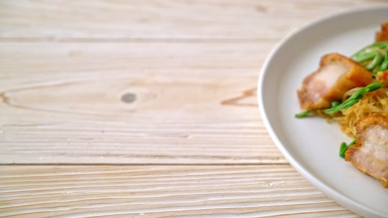 Stir-fried rice vermicelli and water mimosa with crispy pork belly