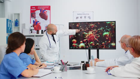 Specialist-medic-explaining-virus-development-pointing-on-monitor