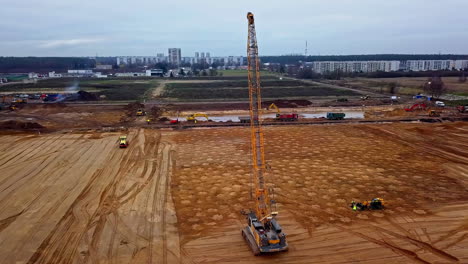 A-crane-dropping-a-weight-at-a-construction-site-for-dynamic-soil-compaction---aerial-view