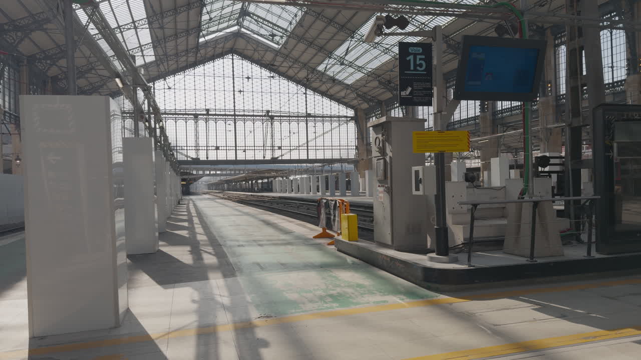 Restored train station in Paris, empty platform under glass roof, calm and bright