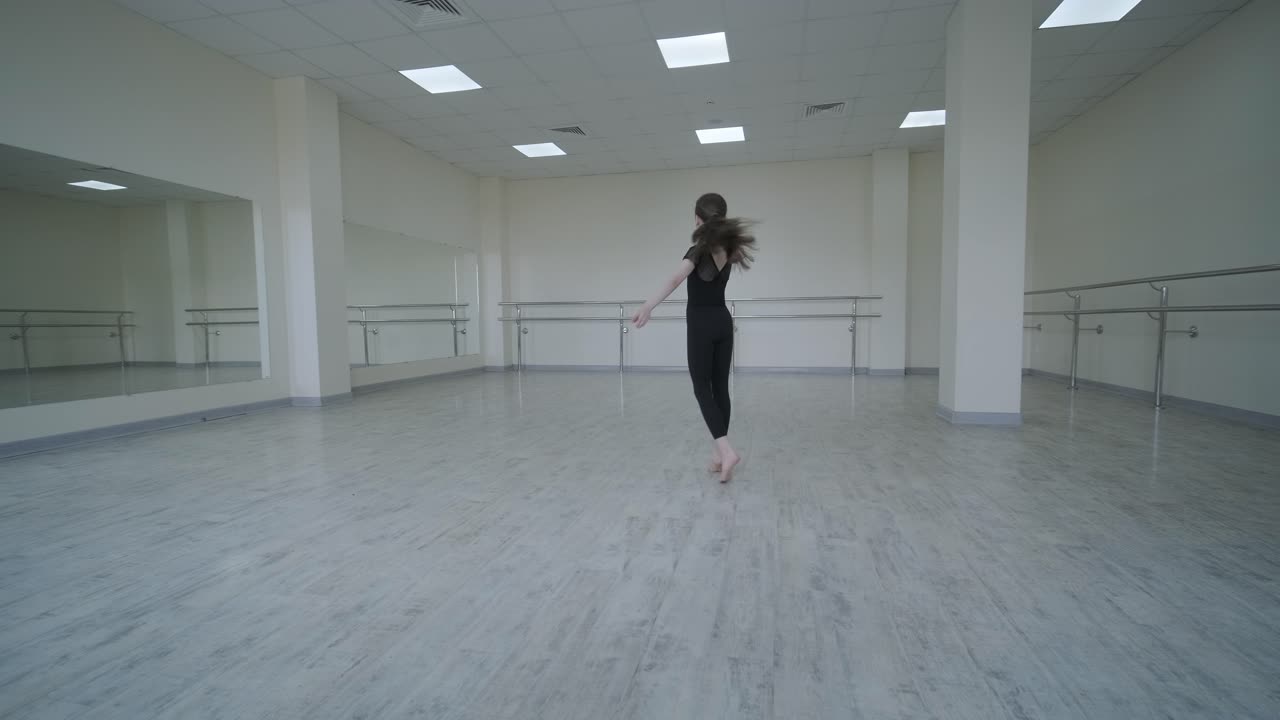 젊은 발레리나 가 스튜디오 에서 춤 을 연습 하고 있다