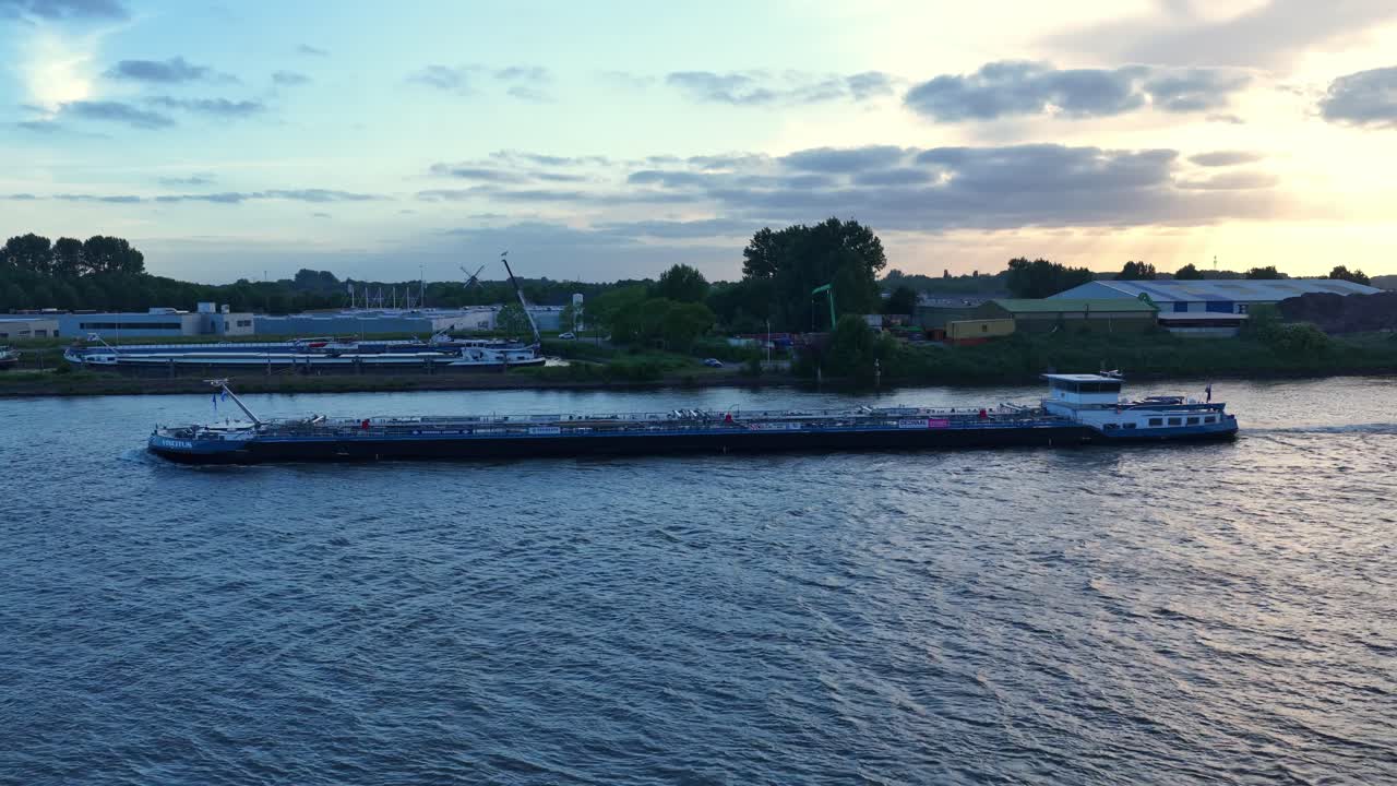 Cargo ship on Dordrecht river at sunset, calm and serene atmosphere