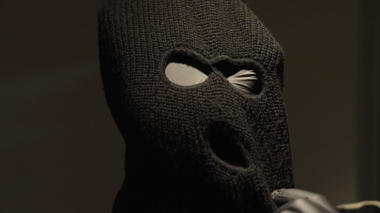 a strummasek or burglar mask is held in front of the camera