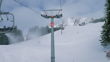 chair lifts and ice flyers moving up and down the snowy mountainside of a skiing destination located at engelberg, in brunni, switzerland