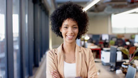 young biracial woman smiling confidently with arms crossed in business casual outfit