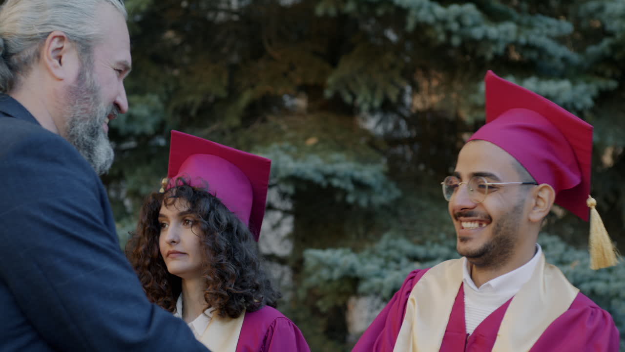 Padre orgoglioso abbraccia il figlio laureato alla cerimonia di laurea