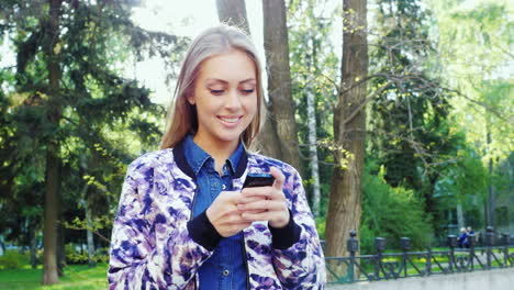 attractive woman enjoying smart phone in a city park the sun shines on it and gives beautiful reflec