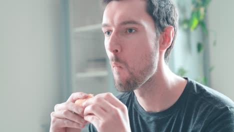 young caucasian man bites into burger at home, cheeseburger eating enjoyment, close up portrait fast food eating, unhealthy eating concept obesity