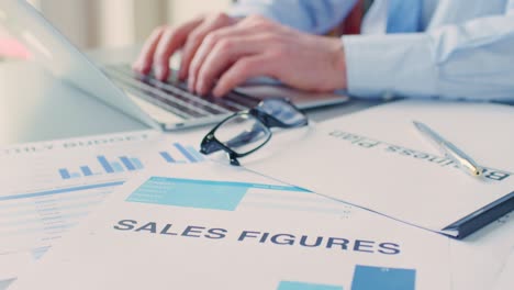 businessman using laptop by sales documents and eyeglasses 4k