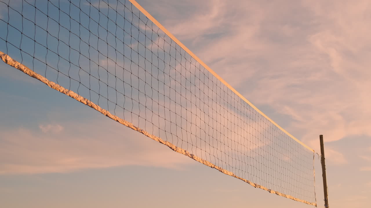 Beautiful bikini girls on the beach play volleyball in slow motion