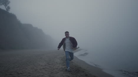 casual guy running sandy beach in morning. young man moving fast along sea shore