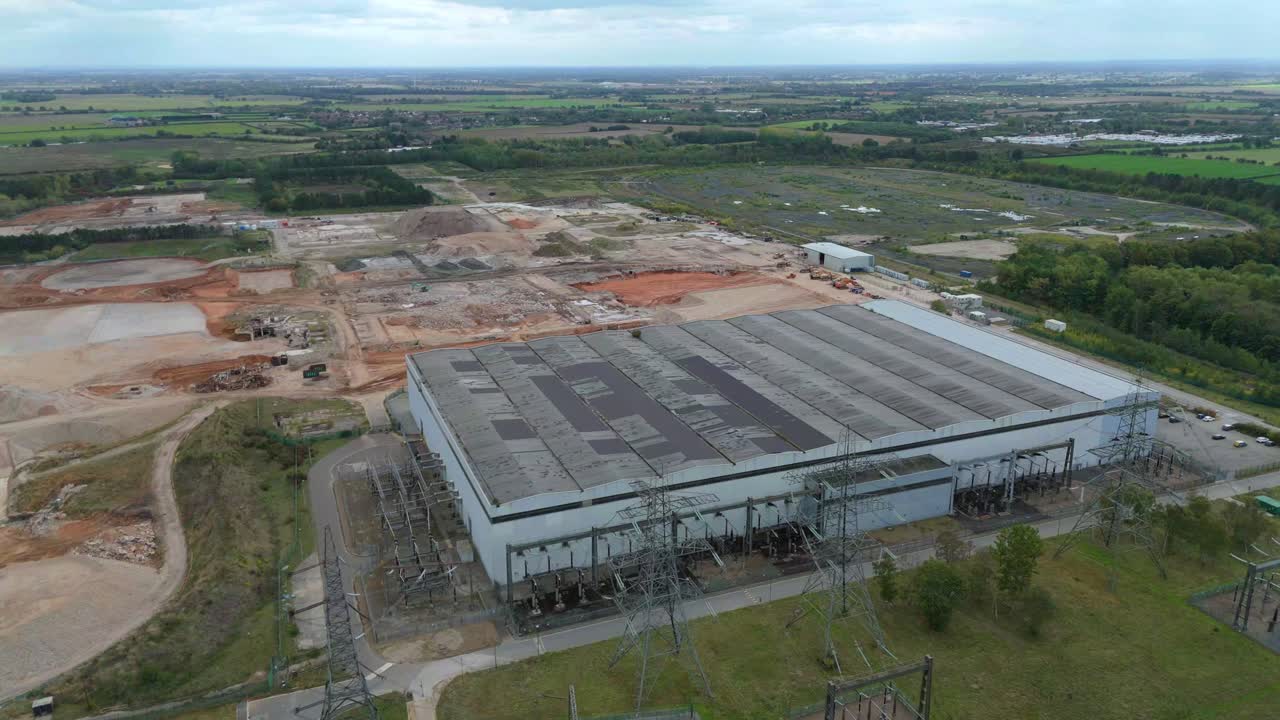 Aerial drone view of decommissioned power plant structure, old powerhouse with derelict pylons powerlines in Yorkshire UK
