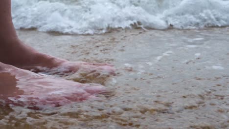 A-barefoot-woman-cools-her-feet-into-the-low-tide-seawater-in-Hong-Kong