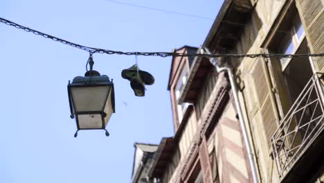 shoes hanging from street lamp in european town