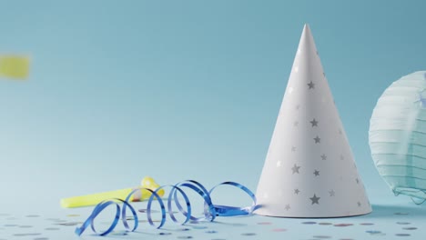 video of white party hat, with streamer and falling confetti, on blue background with copy space