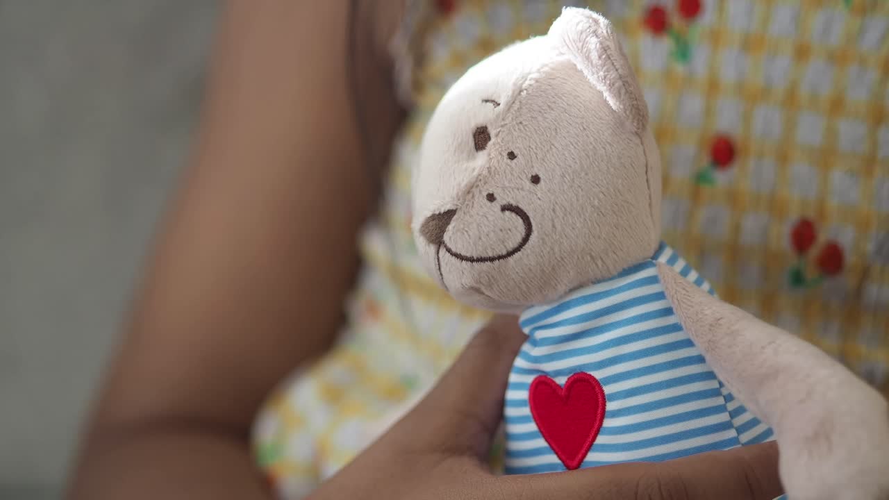 Stuffed teddy bear being held by a child