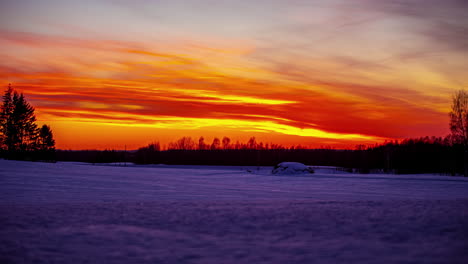 Verschneite,-Winterliche-Landschaft-Im-Zeitraffer-Und-Die-Orangefarbene-Sonne-Am-Horizont,-Wolken,-Die-Am-Himmel-Vorrücken