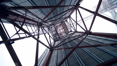 Metal towers on industrial plant.. Steel construction on a modern agricultural factory with grain elevators on sky background