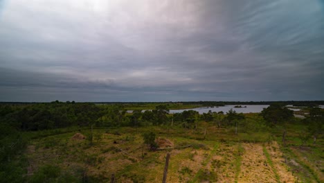 Vast-rural-landscape-with-lake-and-storm-clouds-above-in-Belgium,-time-lapse