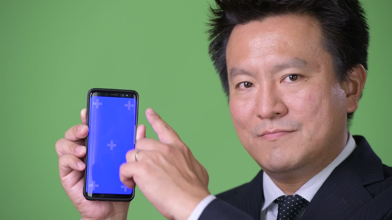 녹색 배경에 성숙한 일본 사업가