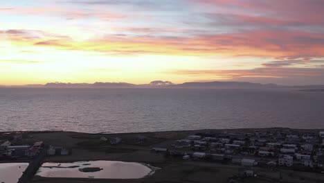 Colorful-sunset-at-NjarÃ°vÃ­k-town-on-Iceland-coast,-aerial