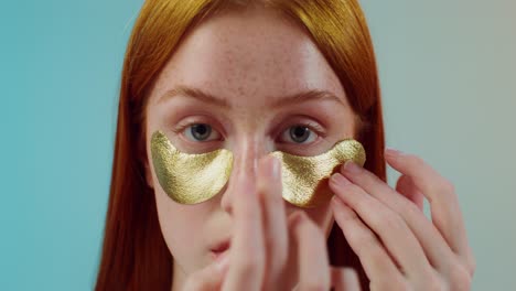 woman applying gold eye patches