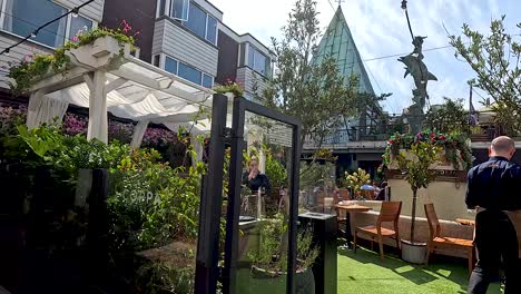 person walking through a garden cafe area