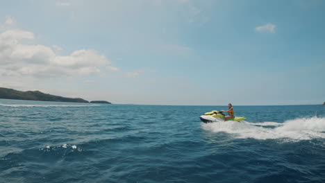 Cinematic-slomo-shot-of-a-jet-ski-running-from-right-to-left-through-the-frame-in-the-clear-blue-ocean-of-the-Philippines,-Asia,-Slow-Motion,-Waverunner