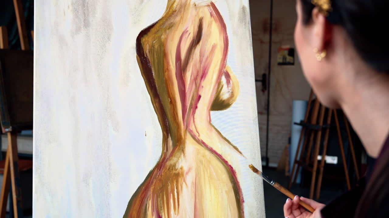 Close up of a woman painting on a canvas at an art gallery workshop