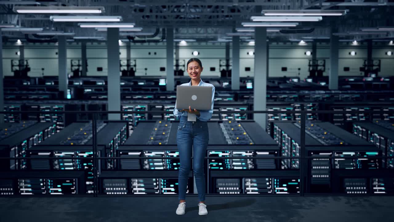 Woman working on a laptop in a server room