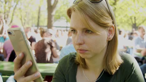 Woman-is-typing-on-her-smartphone-in-a-crowded-place