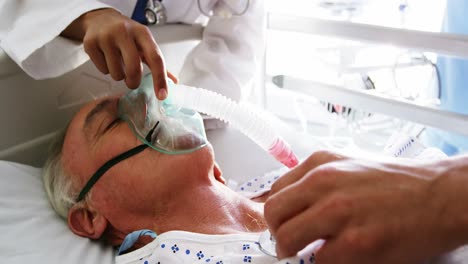 doctor putting oxygen mask on a female senior patient face