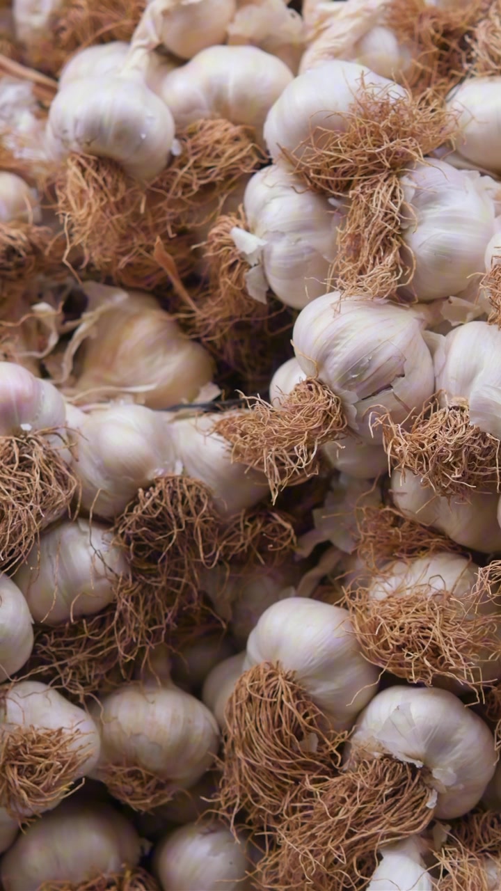 Teste d'aglio fresche impilate al mercato.