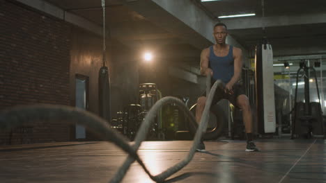 vista inferior de un hombre afroamericano atlético en el gimnasio.