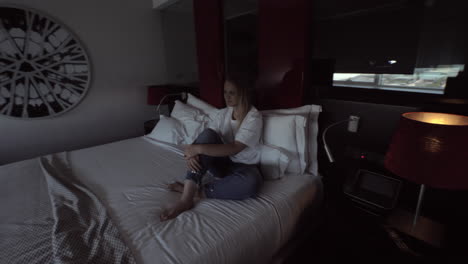 woman sitting in a hotel room and turning on the automatic window opening system