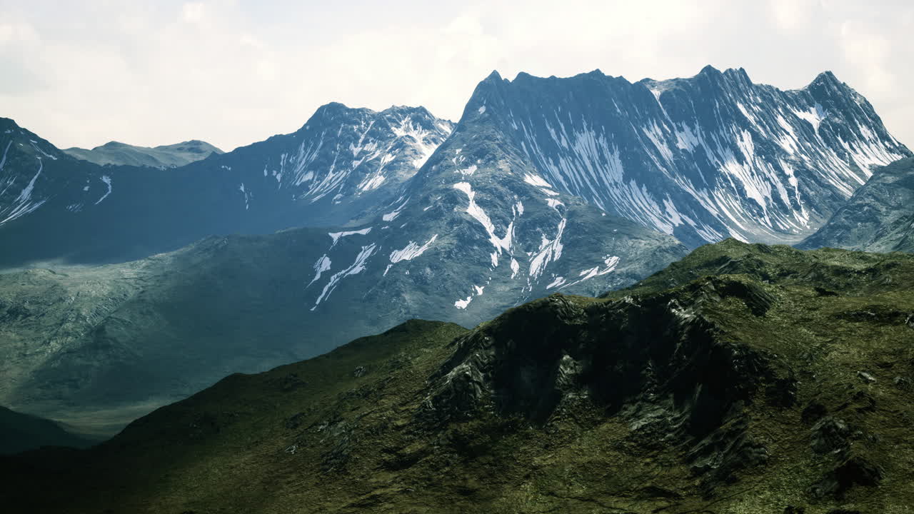 Lanskap gunung yang megah dengan puncak tertutup salju di bawah terangnya siang hari