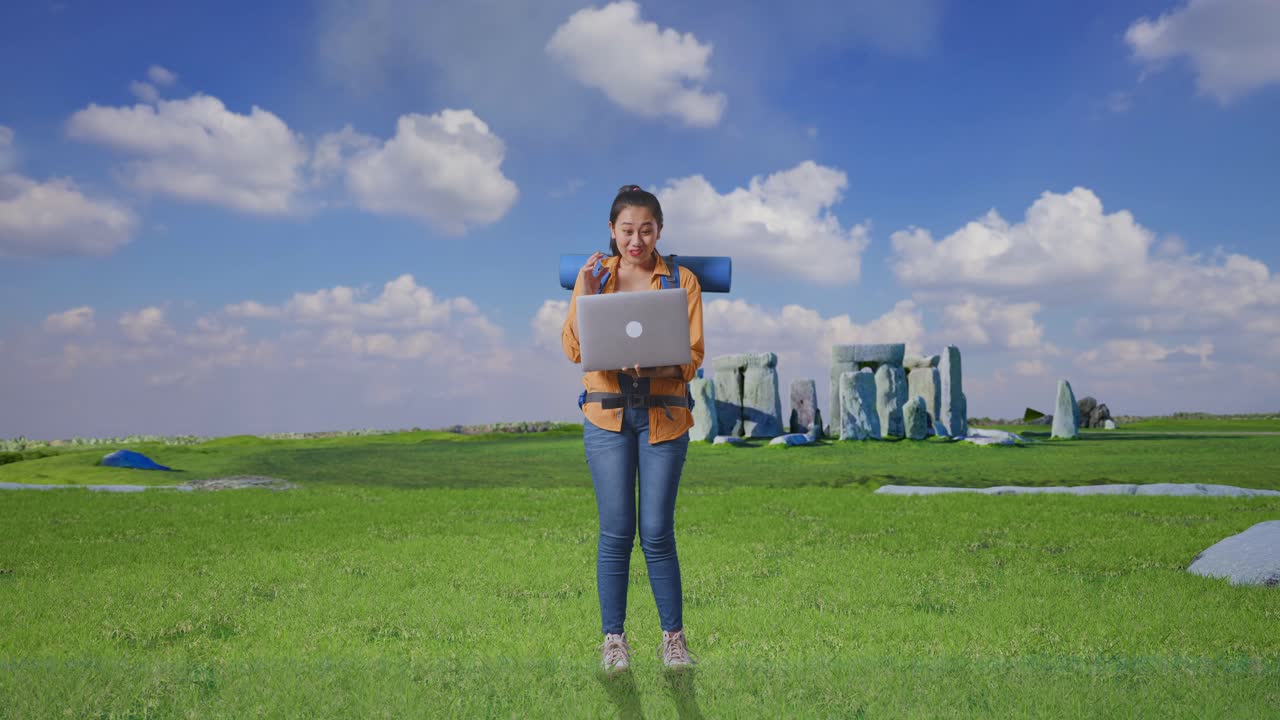 Full Body Of Asian Female Hiker With Mountaineering Backpack Looking At A Laptop And Saying Wow While Traveling In Stonehenge