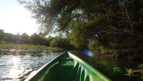 POV-kayaking-on-a-river-France-Herault-summer-sunset-time-trees-calm-water