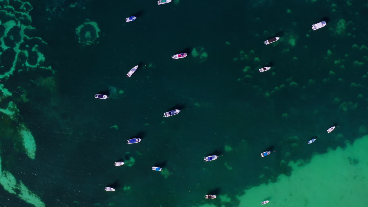 Drone shot revealing dozens of boats parked in shallow waters in the Indian Ocean, Seychelles